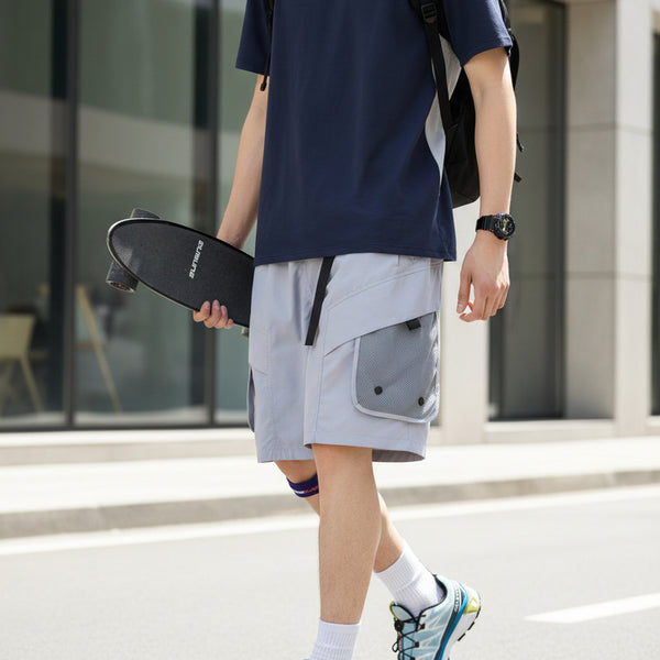 Person wearing gray shorts with a white background