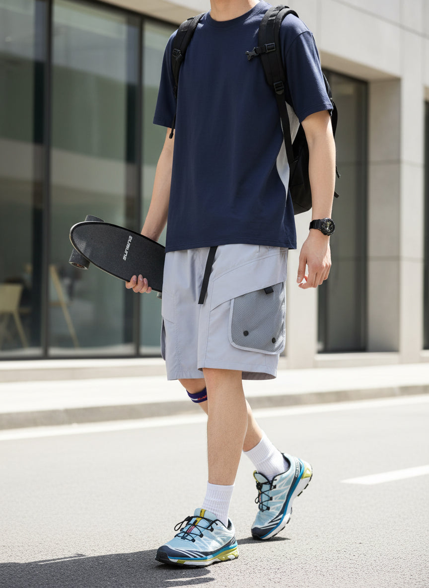 Person wearing gray shorts with a white background